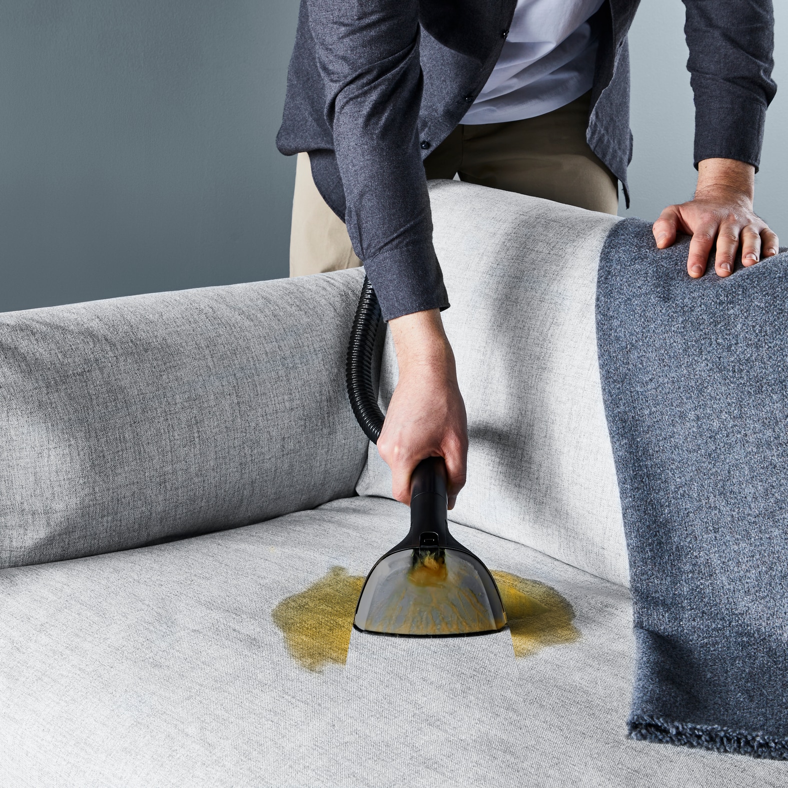 Utilizator român curățând tapițeria canapelei cu Rowenta Clean IT IN5020F0