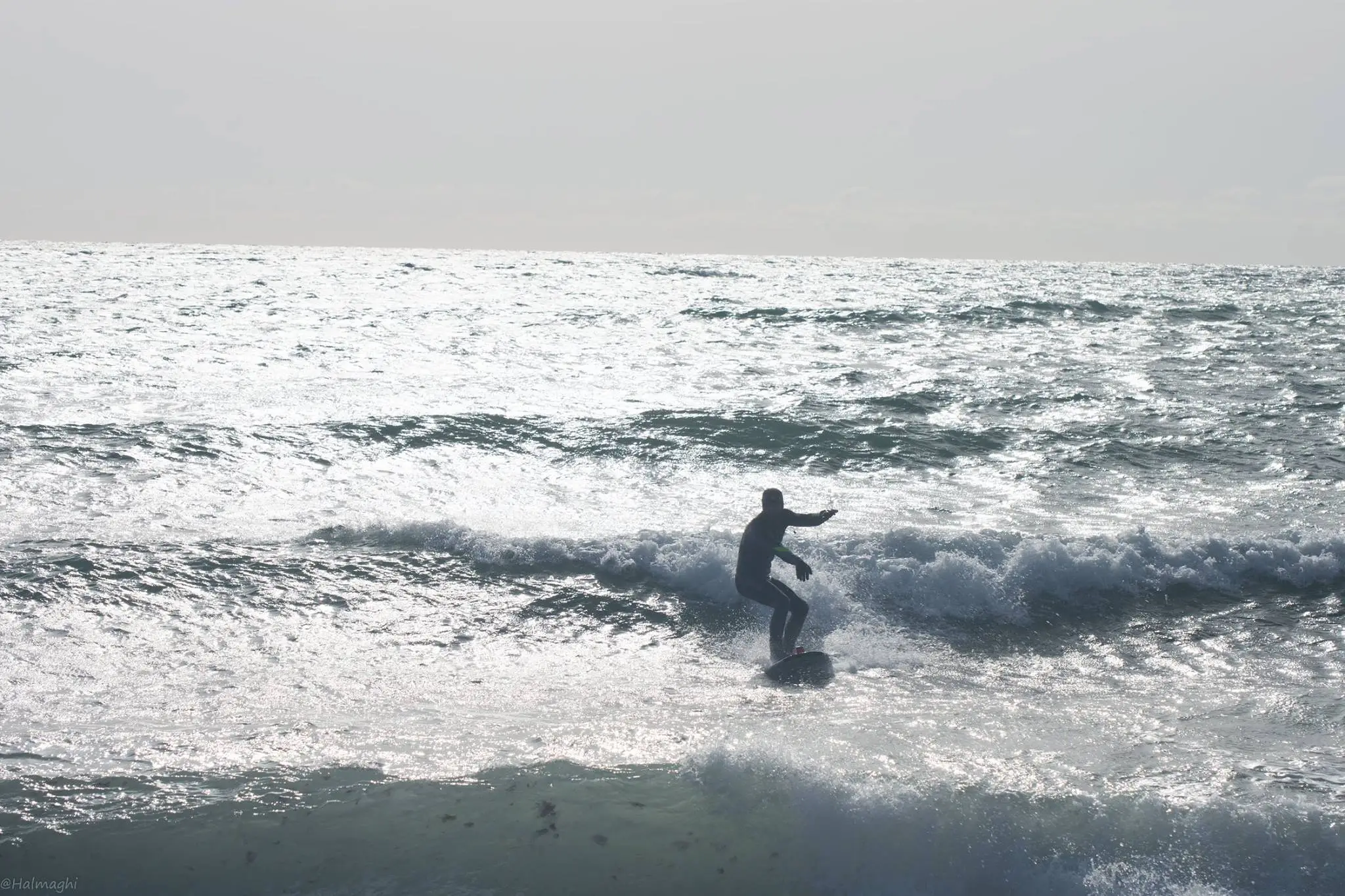 Surfer pe valurile Mării Negre la Vama Veche, România, cu placa de surf